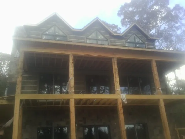 Dormers and porch framing on a large log home under construction — Roof Coating work by our crew in Tygh Valley
