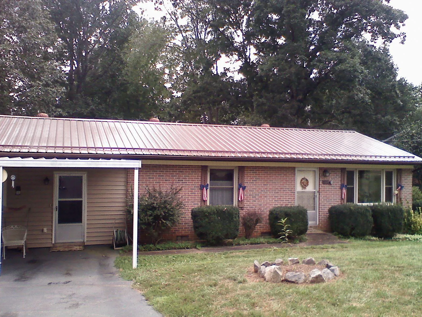 Bronze metal roof and carport on a brick ranch home — Roof Repair work by our crew in Tygh Valley